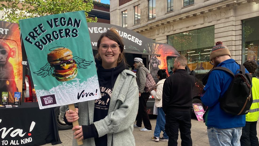 Alice holding a free vegan burgers sign