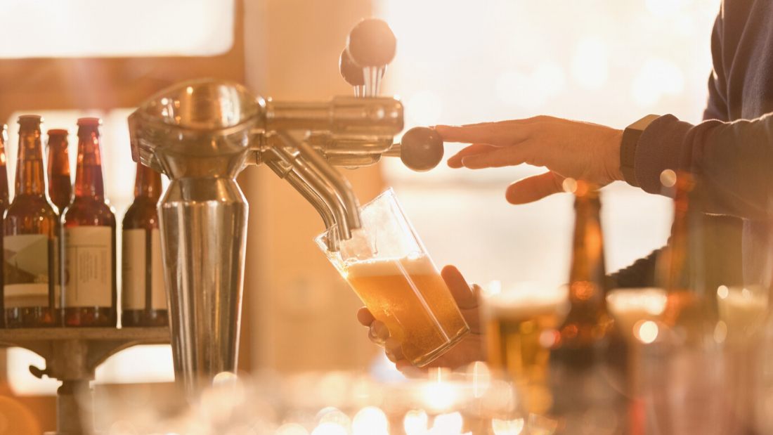 barman pouring a pint of vegan beer