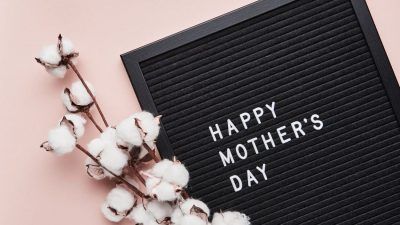 Black board with 'Happy Mother's Day' and flowers on pink background
