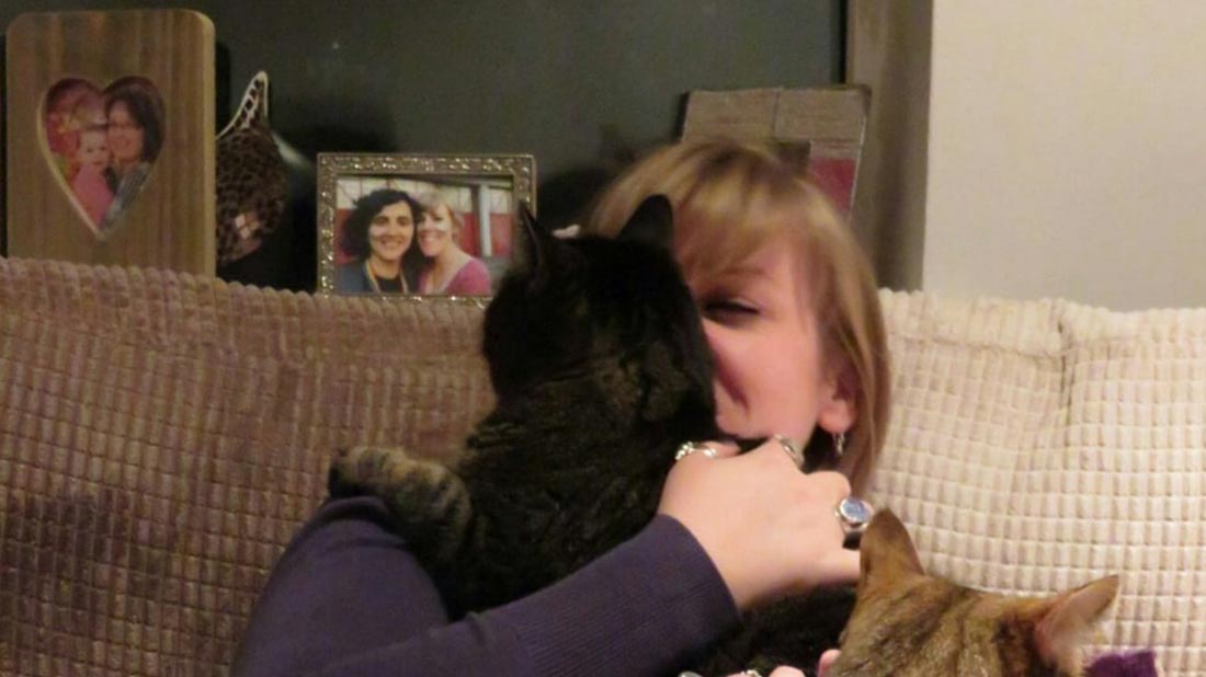 Jess cuddling her cats