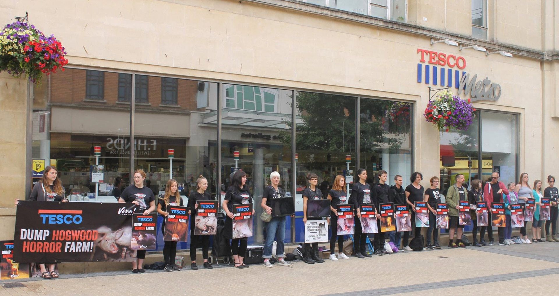 Viva! activists standing outside tesco with placards protesting against hogwood farm in 2018